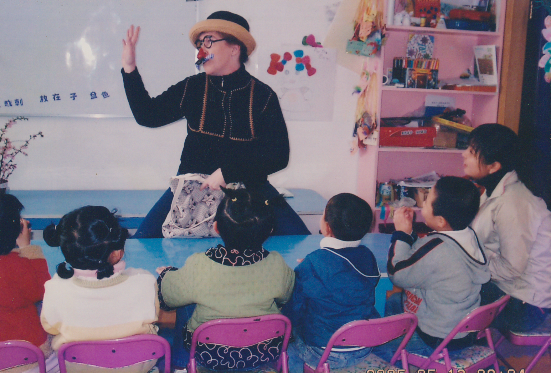 A classroom moment with a visiting teacher and children listening
